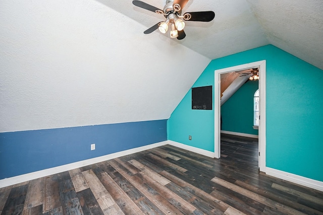 additional living space with lofted ceiling, ceiling fan, dark hardwood / wood-style flooring, and a textured ceiling