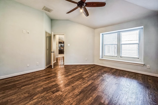 spare room with dark hardwood / wood-style floors, vaulted ceiling, and ceiling fan