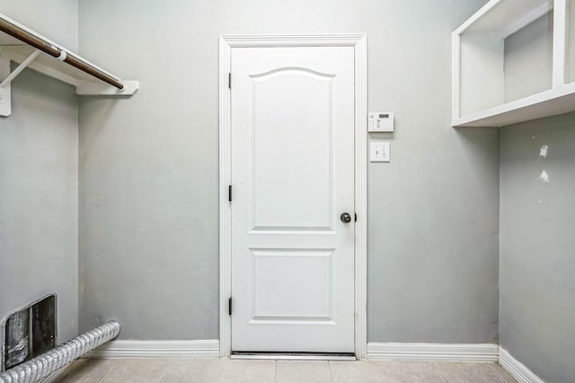 washroom with hookup for an electric dryer and light tile patterned floors