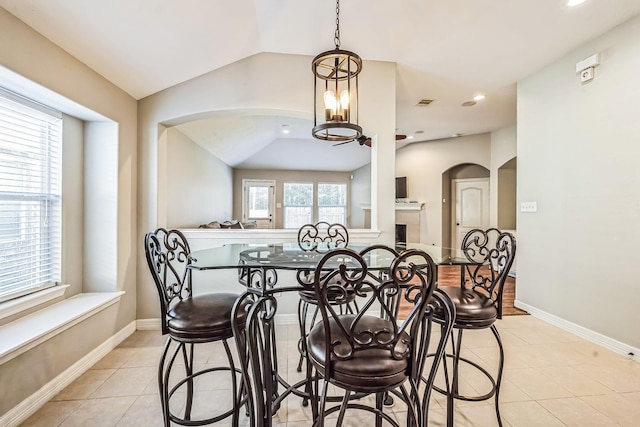 tiled dining area with lofted ceiling and a chandelier