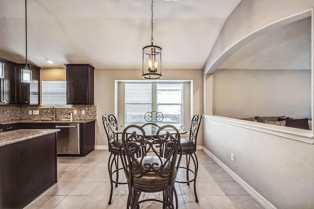 dining space featuring light tile patterned floors, vaulted ceiling, and sink