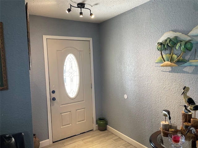 entrance foyer with light hardwood / wood-style floors and a textured ceiling