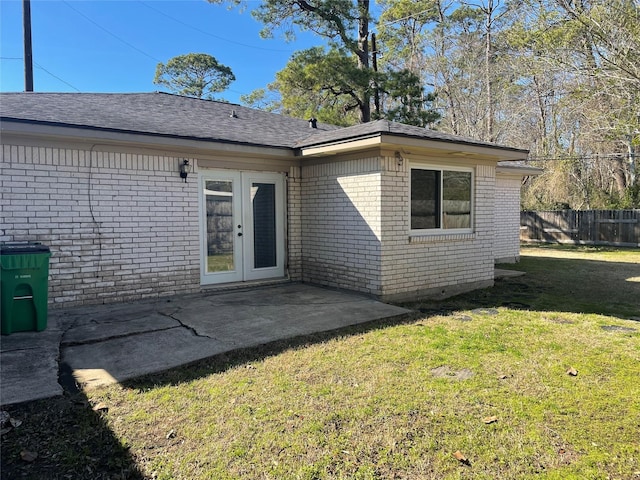 back of house featuring a lawn, a patio area, and french doors