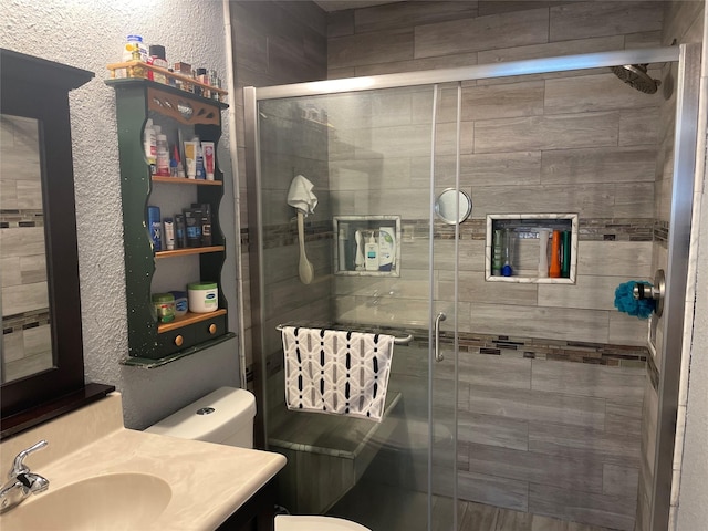 bathroom with vanity, toilet, and a shower with shower door