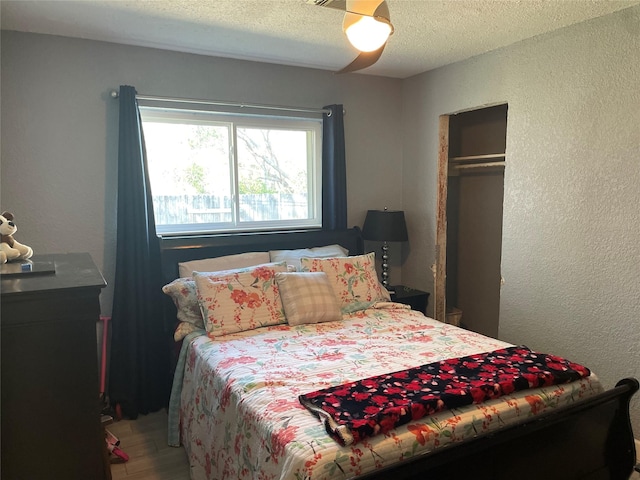 bedroom with ceiling fan, a textured ceiling, and a closet