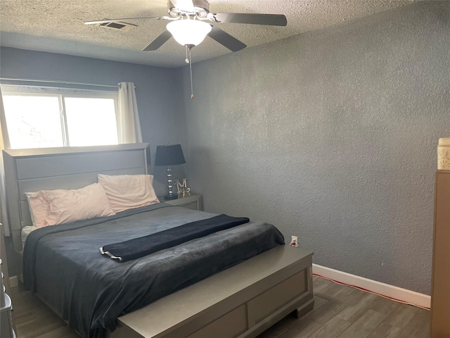 bedroom featuring ceiling fan, a textured ceiling, and hardwood / wood-style flooring