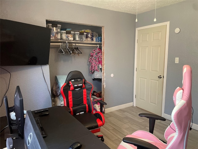 home office with a textured ceiling and hardwood / wood-style flooring