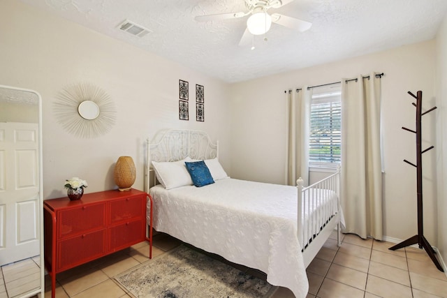 tiled bedroom featuring ceiling fan and a textured ceiling