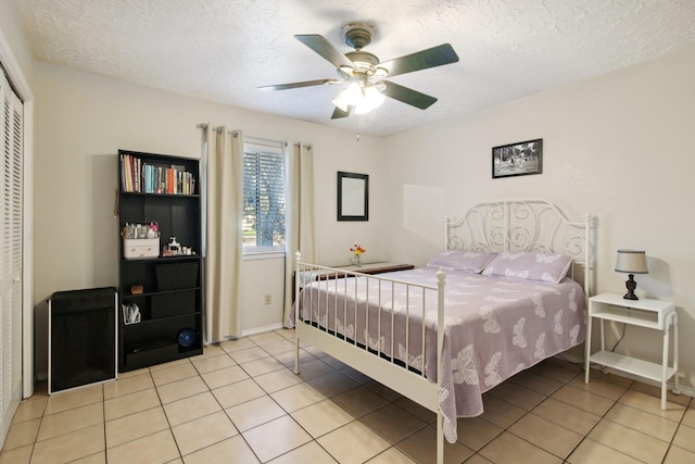 tiled bedroom featuring a textured ceiling, a closet, and ceiling fan