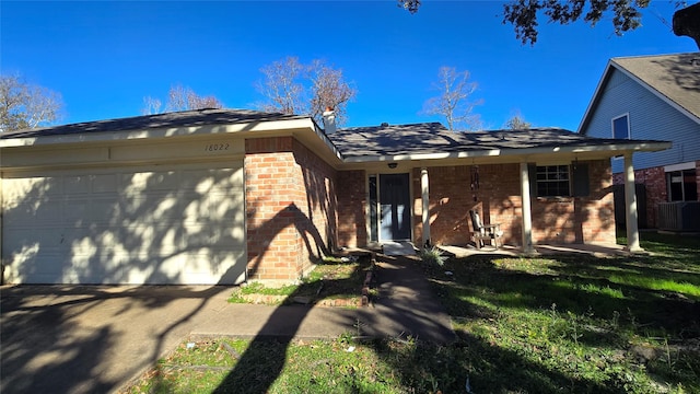 ranch-style house with a front yard, a garage, and cooling unit