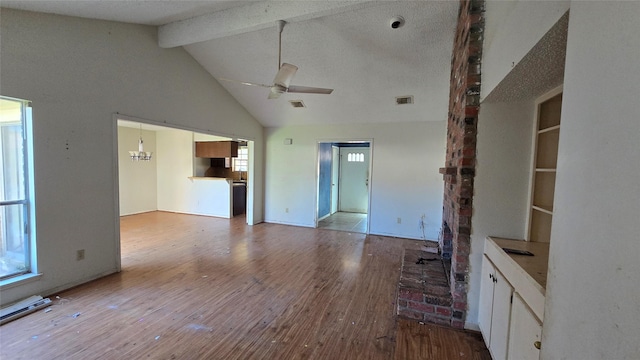 unfurnished living room with hardwood / wood-style flooring, lofted ceiling with beams, and ceiling fan