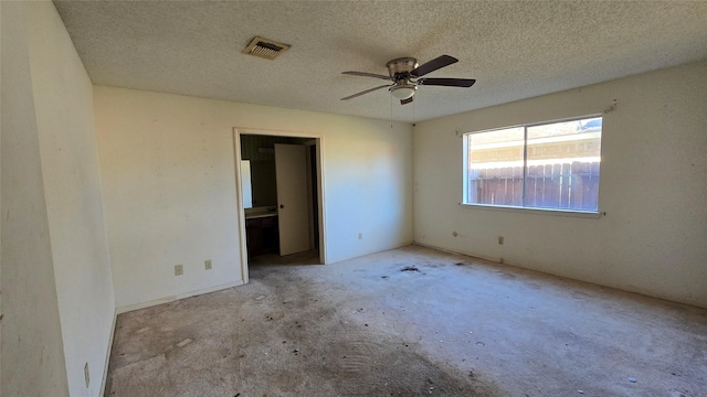 unfurnished bedroom with ceiling fan, a textured ceiling, and ensuite bath