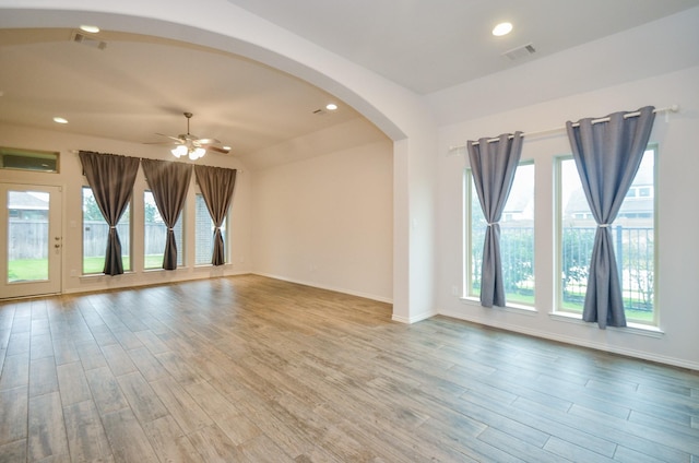 unfurnished room with ceiling fan, light wood-type flooring, lofted ceiling, and plenty of natural light