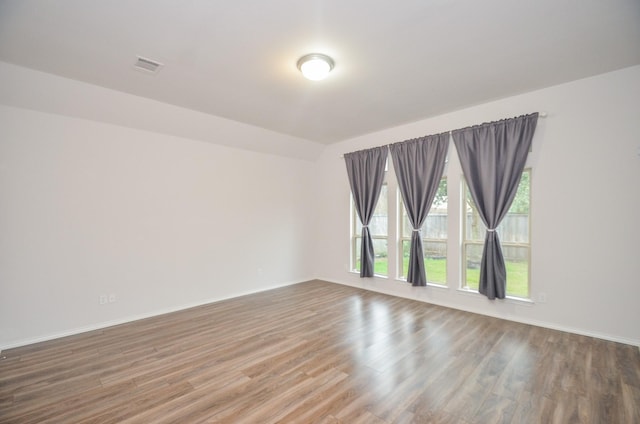 unfurnished room featuring hardwood / wood-style floors and lofted ceiling