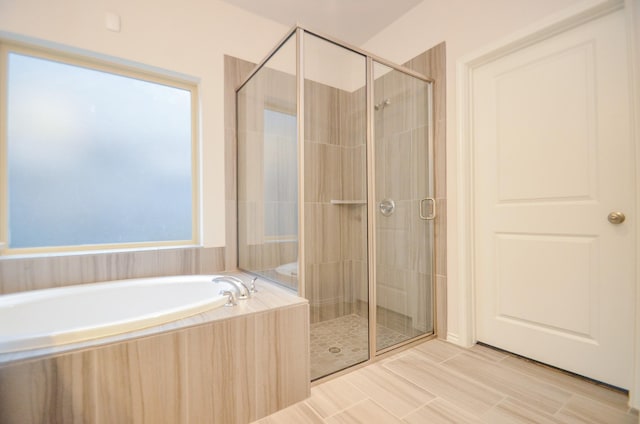 bathroom with plenty of natural light and separate shower and tub