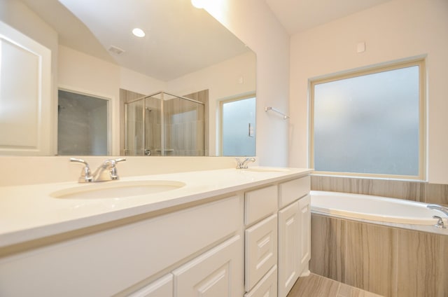 bathroom with vanity and separate shower and tub