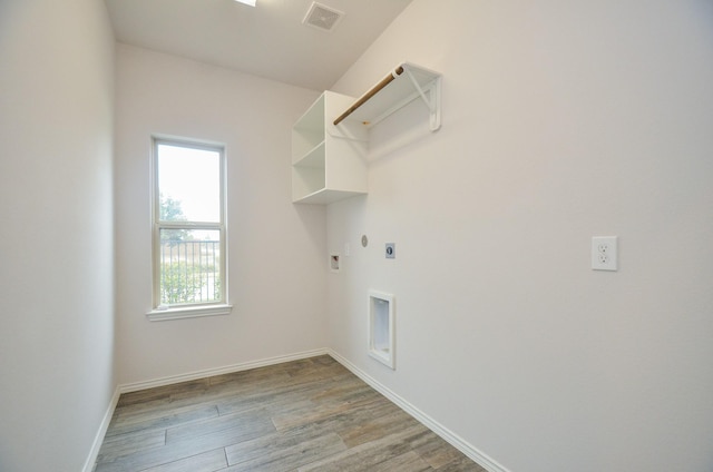 laundry area with gas dryer hookup, light hardwood / wood-style flooring, washer hookup, and hookup for an electric dryer