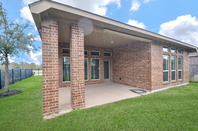 back of property with a patio area and a yard