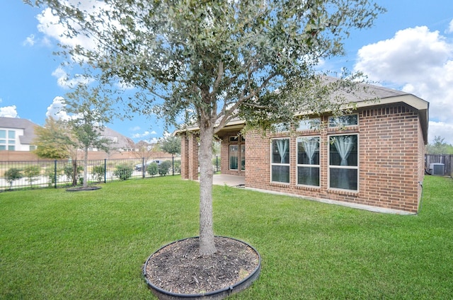 back of property featuring a lawn and central AC unit