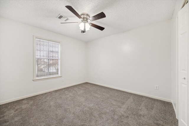 carpeted spare room featuring ceiling fan and a textured ceiling