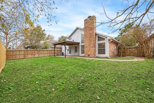 back of house with a yard and a patio