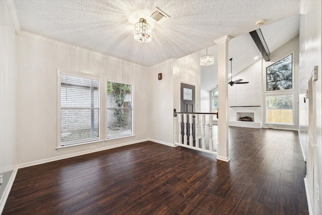 empty room featuring dark hardwood / wood-style floors, a brick fireplace, and plenty of natural light