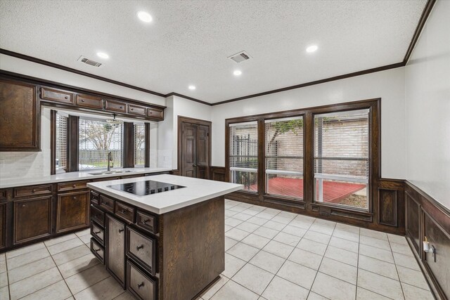 kitchen with a center island, a textured ceiling, black electric cooktop, and sink