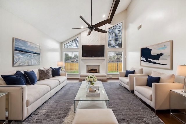 living room with ceiling fan, dark hardwood / wood-style flooring, a fireplace, and high vaulted ceiling