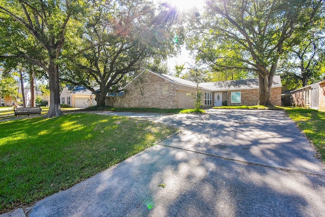 ranch-style home featuring a front lawn and a garage