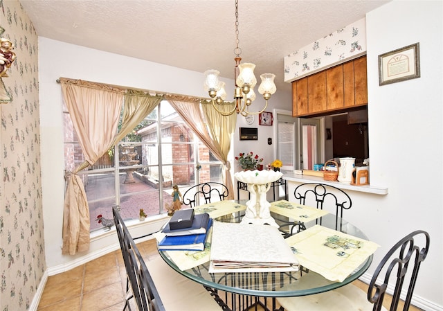 dining area with a notable chandelier, light tile patterned floors, and a textured ceiling