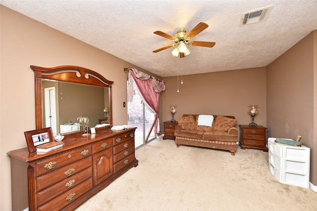 living area featuring light carpet, a textured ceiling, and ceiling fan
