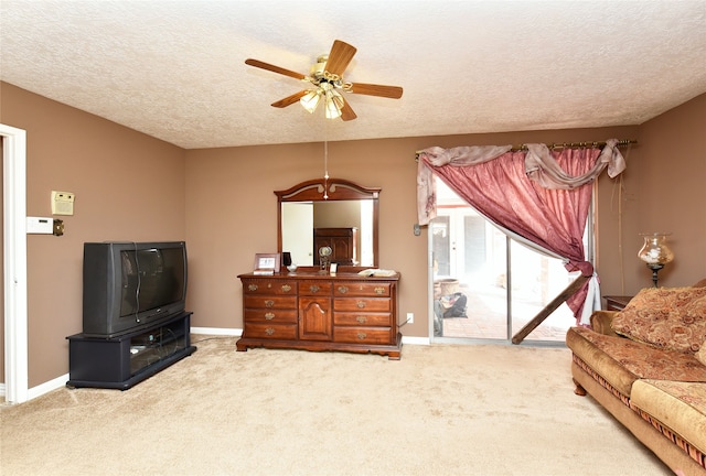carpeted living room featuring a textured ceiling and ceiling fan