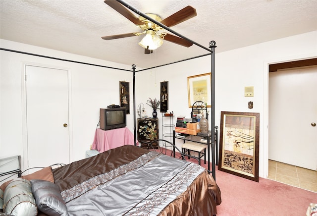 bedroom featuring carpet flooring, ceiling fan, and a textured ceiling