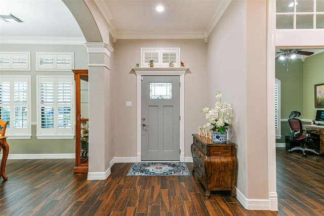 entrance foyer with plenty of natural light, dark hardwood / wood-style flooring, crown molding, and decorative columns