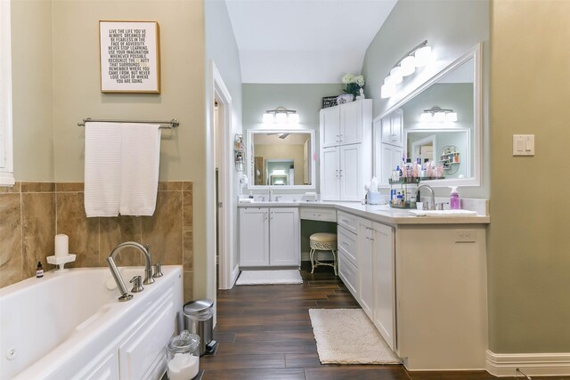 bathroom featuring hardwood / wood-style floors, vanity, a bathtub, and lofted ceiling