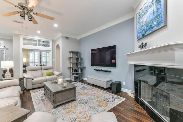 living room featuring ceiling fan, crown molding, and dark wood-type flooring