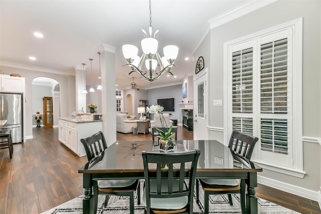 dining area featuring dark hardwood / wood-style flooring, ceiling fan with notable chandelier, and ornamental molding