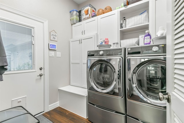 clothes washing area with cabinets and separate washer and dryer