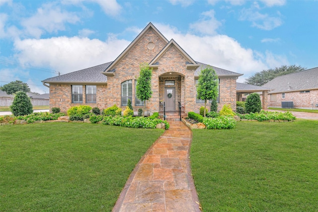 view of front of home with a front yard and central AC