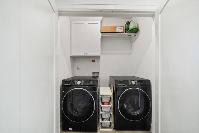 washroom featuring washing machine and dryer and cabinets