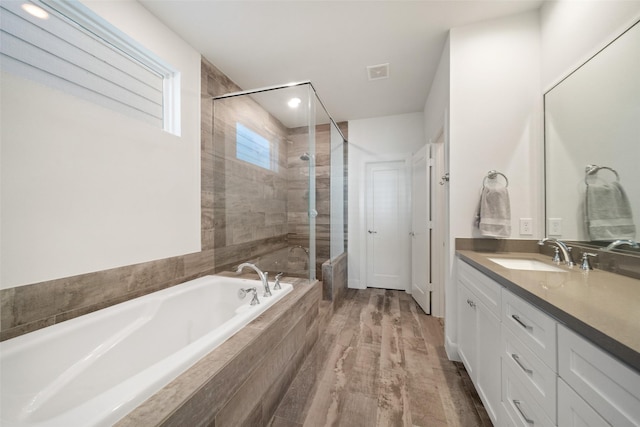 bathroom featuring hardwood / wood-style floors, vanity, and separate shower and tub