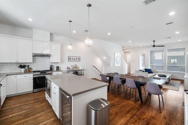 kitchen featuring white cabinets, a center island, stainless steel appliances, and ceiling fan