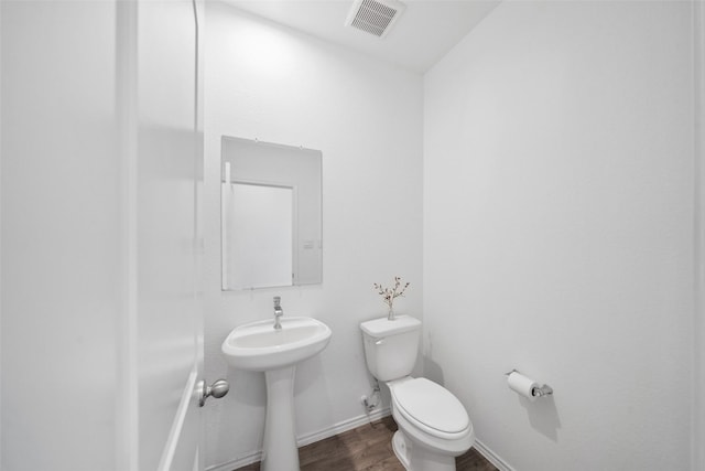 bathroom with toilet, sink, and hardwood / wood-style flooring