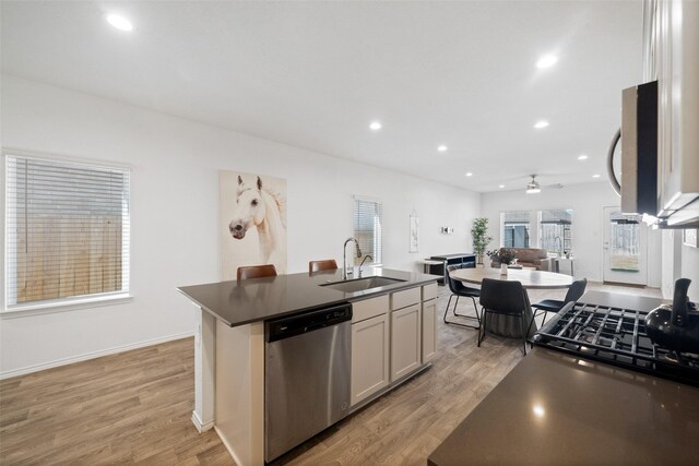 kitchen featuring ceiling fan, sink, stainless steel appliances, and a kitchen island with sink