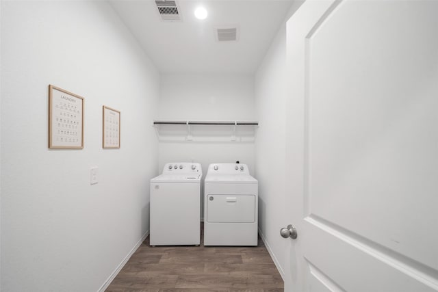 washroom featuring hardwood / wood-style flooring and washer and clothes dryer