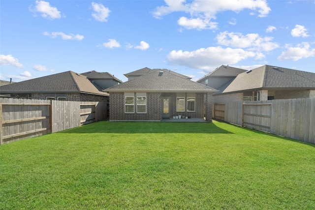 rear view of property featuring a patio area and a lawn