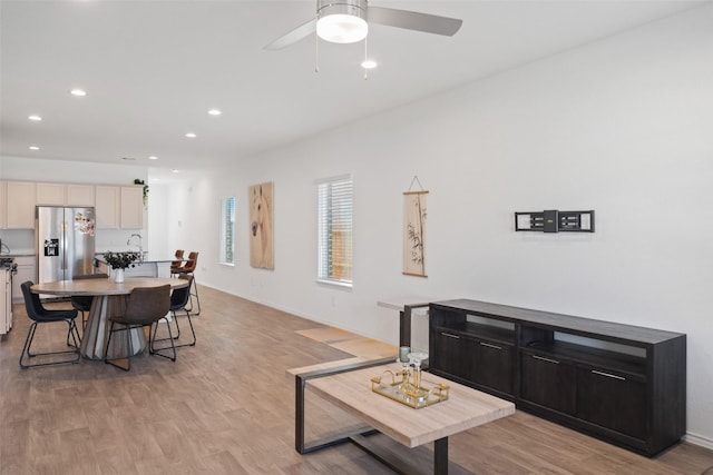 living room featuring ceiling fan and light hardwood / wood-style floors