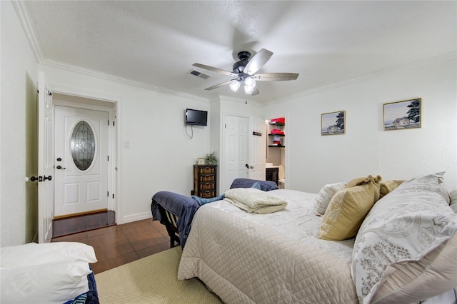 bedroom featuring a textured ceiling, dark tile patterned flooring, ceiling fan, and crown molding