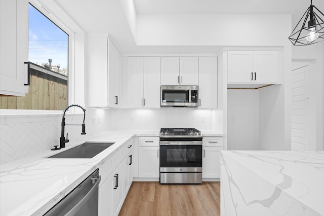 kitchen with white cabinetry, sink, pendant lighting, and appliances with stainless steel finishes