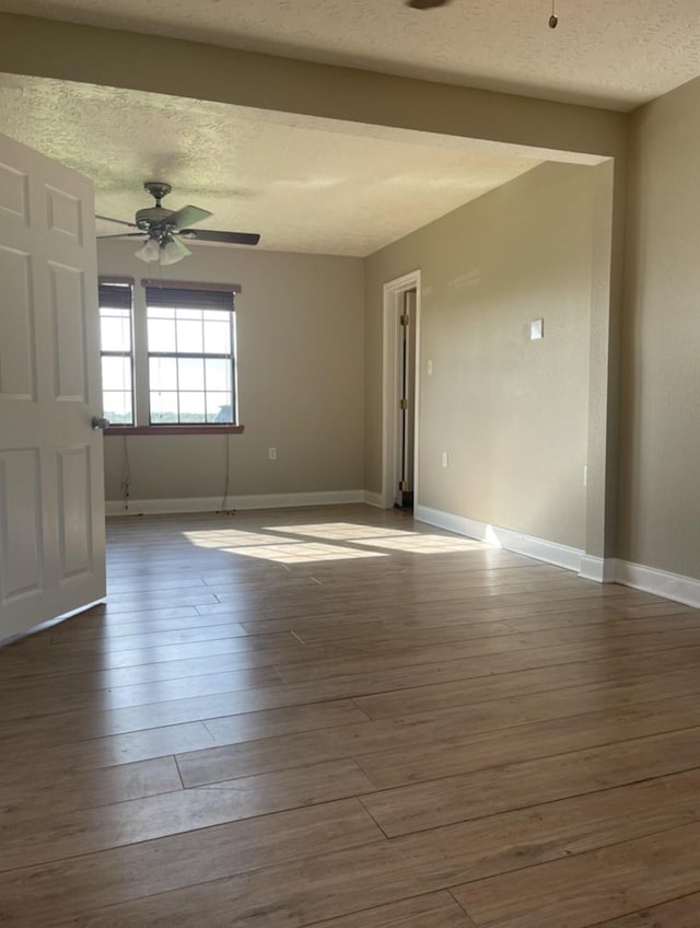 spare room with hardwood / wood-style floors, a textured ceiling, and ceiling fan